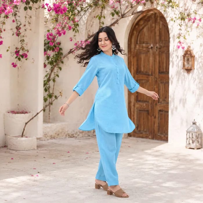 Sky blue co-ord, worn beside a wooden door framed with bougainvillea
